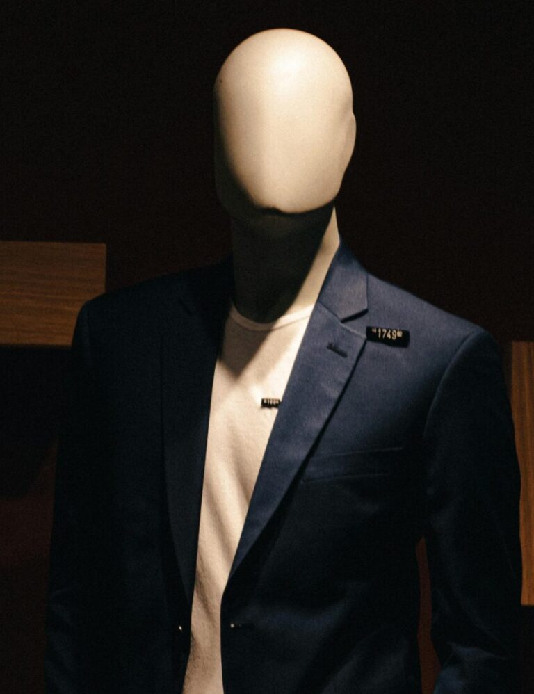 Stylish mannequin in a formal suit in low light, ideal for fashion and retail themes.